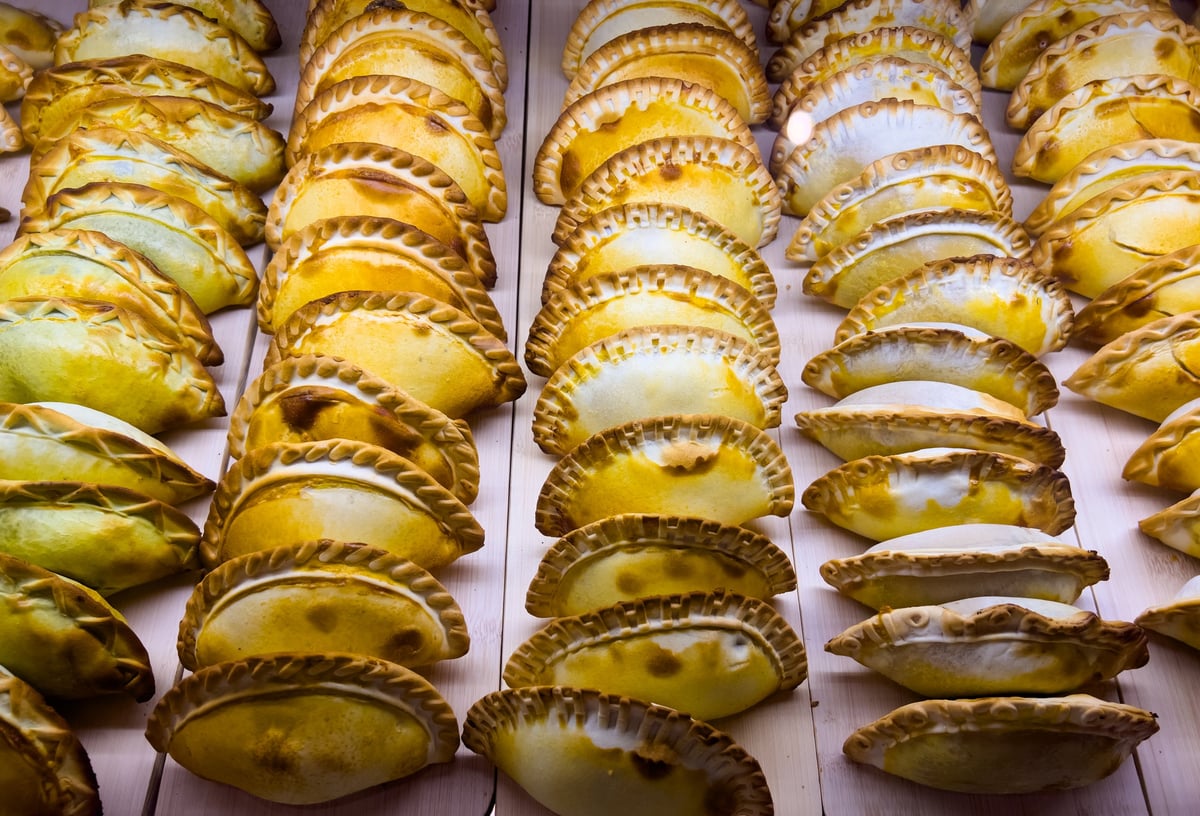 Empanadillas recién horneadas de distintos rellenos y formas en el mostrador de la pastelería