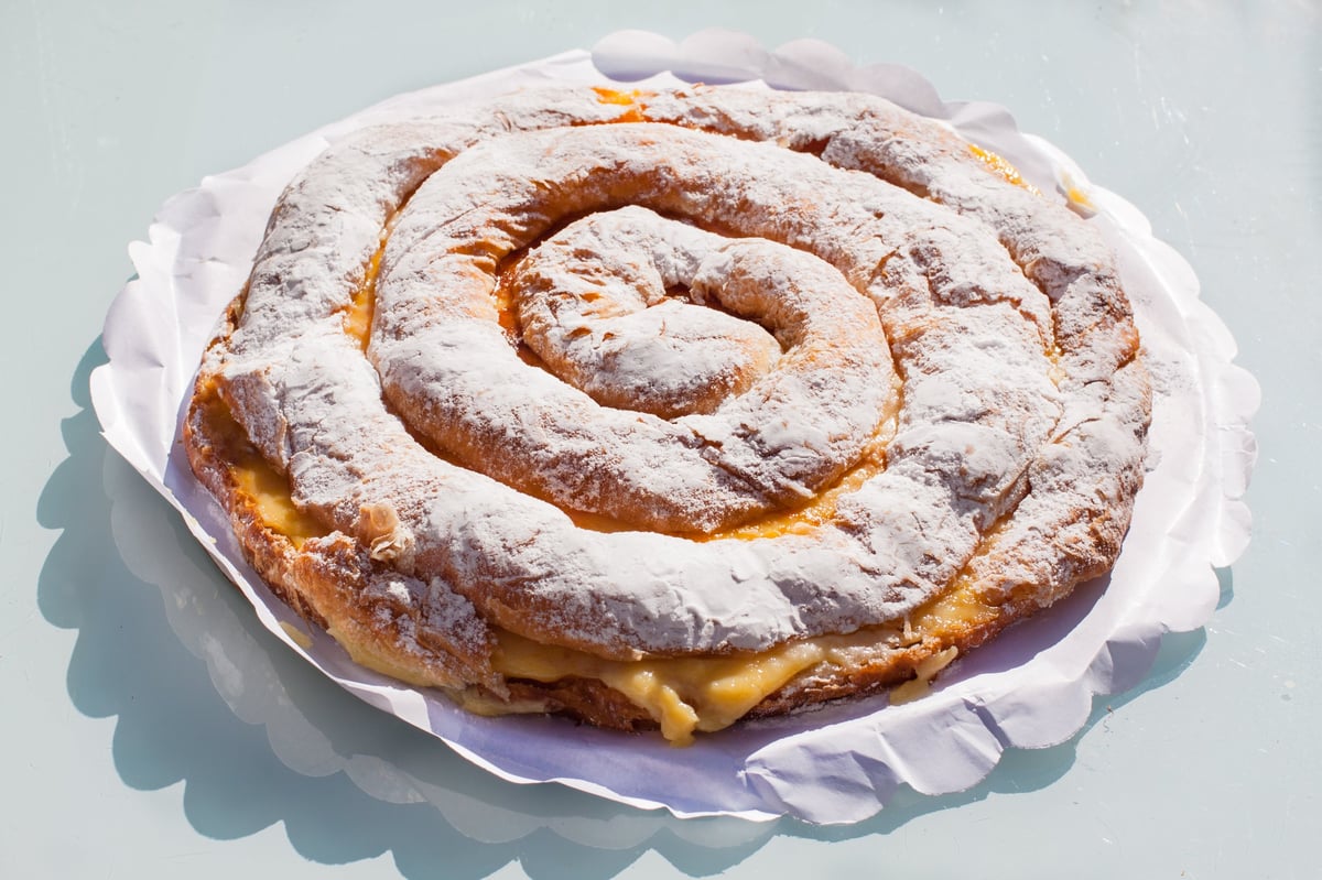 Ensaimada en espiral con crema y azúcar glas espolvoreado